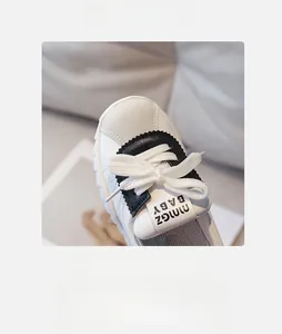 Detail view of the wide round toe and white laces on children's leather sneakers