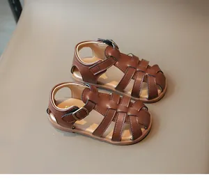 Close-up of brown woven children's sandals featuring vintage faux leather and velcro straps