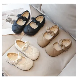 Dettaglio di scarpe Mary Jane da bambina con motivo a rombi trapuntato e fiocco decorativo