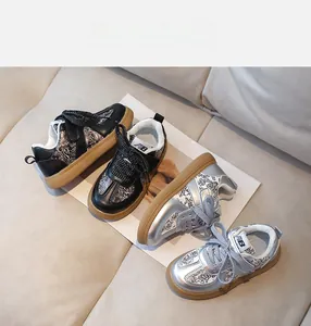 Detail view of kids casual sneakers with floral patterns and gum soles in black and silver