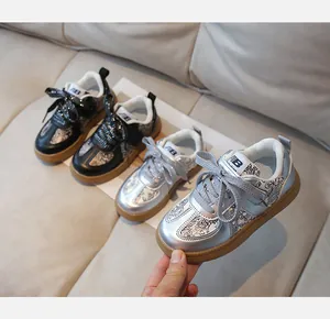 Detail of children's fashion sneakers showing metallic textures and rubber soles
