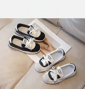 Detail view of two pairs of casual kids sneakers with contrast stitching and soft soles