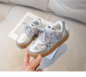 Detail of silver metallic kids sneaker with floral patterns and non-slip rubber sole