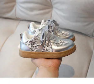 Detail of silver metallic kids sneaker with floral print and rubber gum sole