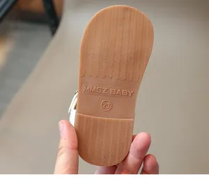Close-up of caramel non-slip wavy rubber sole with embossed logo and size 23
