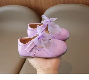 Detail of purple girls Mary Jane shoe with glossy patent leather and mesh bow