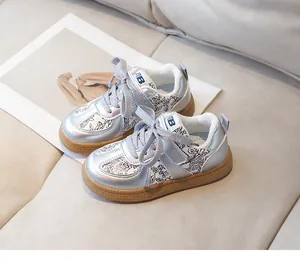 Detail of kids' silver sneakers featuring floral patterns and a thick rubber sole