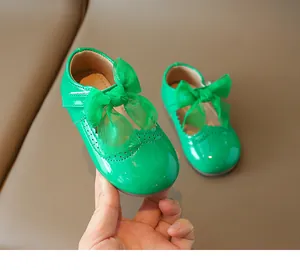 Close-up of green patent leather girls' Mary Jane shoes with large chiffon bow details