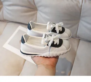 Detail of children's white leather sneakers featuring soft wavy soles and MNGZ BABY logo