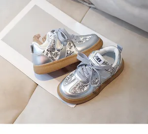 Detail view of silver kids sneakers with floral panels and durable gum rubber soles