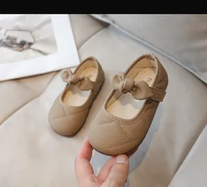 Dettaglio di ballerine Mary Jane trapuntate beige per bambina con fiocco e cinturino a strappo
