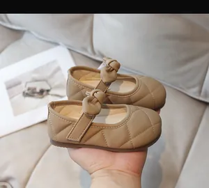 Dettaglio scarpe Mary Jane cachi da bambina con fiocco e cuciture trapuntate
