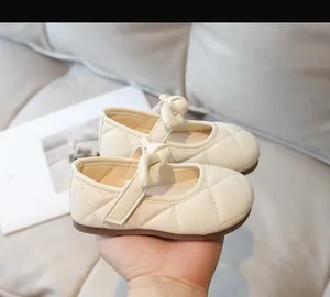 Dettaglio delle scarpe Mary Jane trapuntate beige per bambine con fiocco e suola in gomma