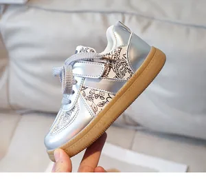 Detail of silver kids' floral sneaker showing velcro strap and durable gum rubber sole
