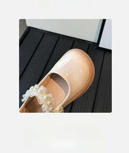 Detailed macro view of girls Mary Jane shoes featuring pearl beads and lace ruffles