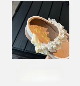 Detailed macro view of girls Mary Jane shoes with pearls, lace trim, and soft inner sole