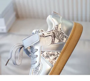 Detailed shot of kids silver metallic sneakers with velcro straps and retro print fabric