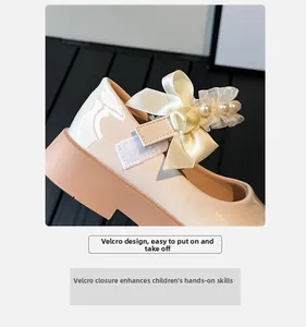 Close-up of girls' Mary Jane shoes with velcro strap, silk bow, and pearl detailing