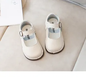 Gros plan de chaussures Mary Jane blanches avec texture cuir et bride à boucle réglable