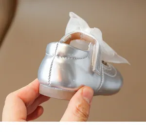 Detail of silver girls princess shoe featuring a mesh bow and soft rubber sole
