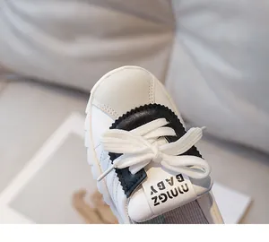 Detail of white leather kids sneaker with suede patchwork and NINGZ BABY tongue label