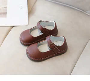 Vue de dessus de babies en cuir marron foncé avec boucles métalliques et coutures fines
