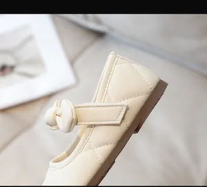 Dettaglio delle scarpe Mary Jane panna per bambina con trapuntatura e fiocco decorativo