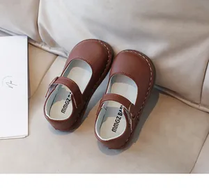 Détail de chaussures Mary Jane en cuir marron montrant les coutures et la boucle réglable