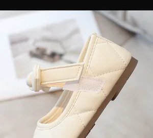 Dettaglio delle scarpe Mary Jane beige trapuntate da bambina con cinturini in velcro