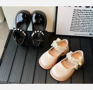 Detail showing pearl straps, lace ruffles, and shiny bows on little girl Mary Jane shoes