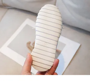 Close-up of flexible white children shoe sole with anti-slip texture and size 27 mark