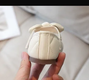 Dettaglio della scarpa Mary Jane beige da bambina con tallone trapuntato e fiocco