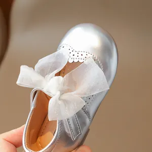 Silver girls Mary Jane shoes with white tulle bow and decorative hollow-out details