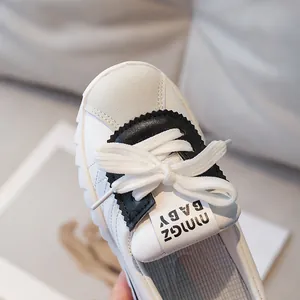 Kids minimalist white leather sneakers with grey suede toe and black sawtooth trim details
