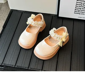 Detail of girls Mary Jane shoe with cream patent leather and pearl lace bow accents