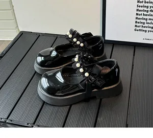 Detail of girls Mary Jane shoe with black patent leather, lace trim and pearl bow
