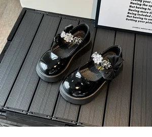 Détail de chaussures Mary Jane noires vernies pour filles avec sangle à fleurs en strass