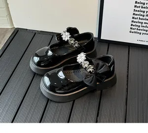Détail de chaussures Mary Jane en cuir verni noir avec fleurs en strass et nœuds