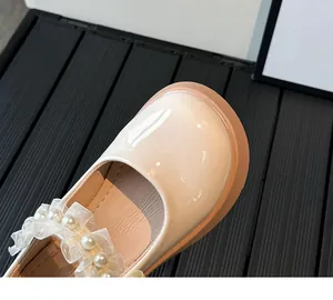 Detail of girl's Mary Jane shoe featuring lace ruffles and pearl accents on the strap
