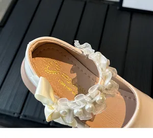 Detail of pink Mary Jane shoe featuring cream lace trim, faux pearls and satin bow