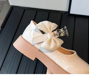 Gros plan de chaussures Mary Jane avec nœud organza, bride strass et semelles roses