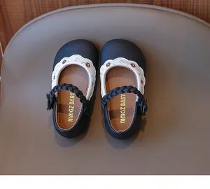 Detailansicht von schwarzen Mädchen-Mary-Janes mit Blumenstickerei und gewelltem weißem Rand