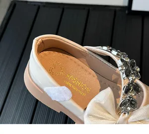 Détail de chaussure Mary Jane pour fille avec nœud en soie et bride ornée de strass