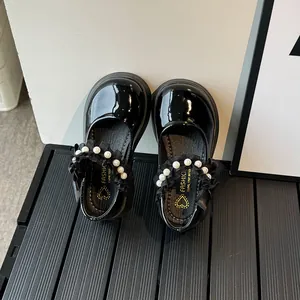 Glossy black Mary Jane shoes for girls with pearl strap and lace ruffle details