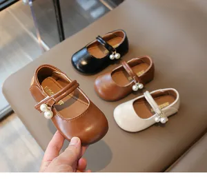 Detail of toddler Mary Jane shoes with elegant pearl charms in brown, black, and beige