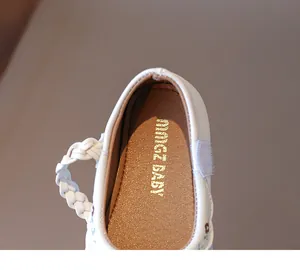 Detailaufnahme weißer Prinzessinnenschuhe für Mädchen mit feiner Lederflechtung und Stickerei