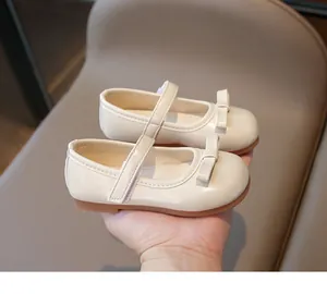 Close-up of baby Mary Jane shoes in cream with a lovely bow and velcro strap detail