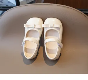 Detailed top view of cream Mary Jane shoes with bow decoration and velcro strap