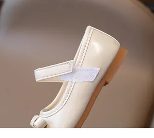 Detail shot of beige Mary Jane shoes for girls featuring glossy finish and hook-and-loop strap