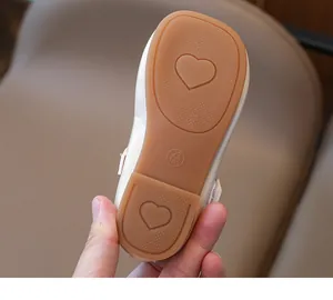 Detail of baby girl shoe rubber sole with anti-slip heart patterns and size 23 mark